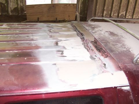 1988 Ford C-350 (Centurion Conversions) - The roof of a maroon vehicle shows significant bodywork damage and repairs.