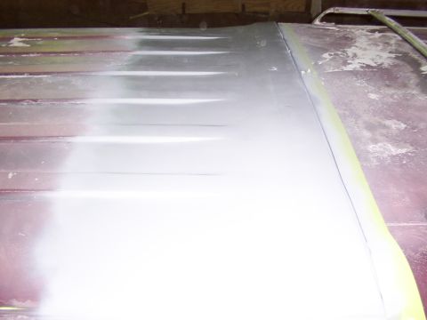 1988 Ford C-350 (Centurion Conversions) - Close-up of a vehicle roof panel undergoing bodywork, with primer applied to a section.
