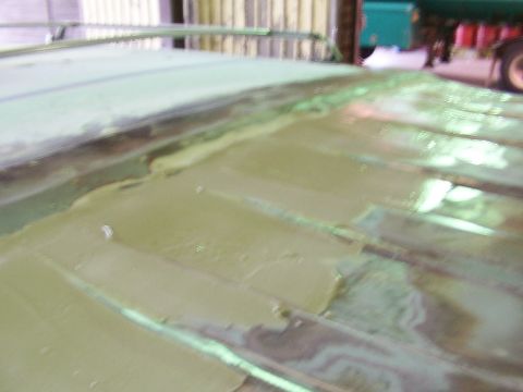 1988 Ford C-350 (Centurion Conversions) - The roof of a vehicle is covered in green primer and shows visible seams, indicating bodywork is in progress.