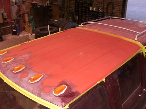 1988 Ford C-350 (Centurion Conversions) - The roof of a vehicle is prepped for painting, showing amber clearance lights and a roof rack.
