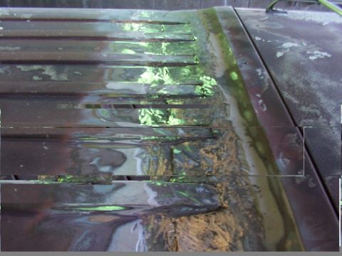 1988 Ford C-350 (Centurion Conversions) - Close-up of a dark brown roof panel horizontal louvers and areas of rust repair, indicating bodywork in progress.