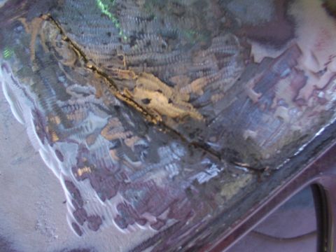 1988 Ford C-350 (Centurion Conversions) - Close-up view of a damaged metal panel showing a crack and evidence of welding repairs.