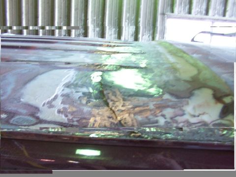 1988 Ford C-350 (Centurion Conversions) - Close-up view of body filler and primer on a vehicle's roof, indicating repair work.