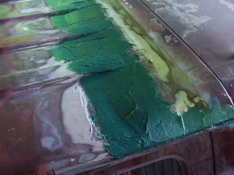 1988 Ford C-350 (Centurion Conversions) - Body filler applied to a vehicle's roof panel during repair work.