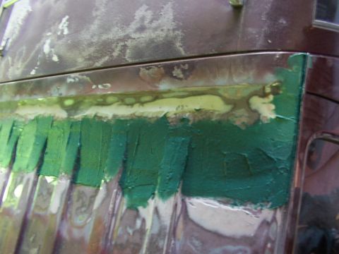 1988 Ford C-350 (Centurion Conversions) - Body filler and tape are applied to a section of a vehicle's exterior during repair work.