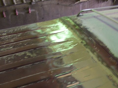 1988 Ford C-350 (Centurion Conversions) - Close-up view of a vehicle's roof undergoing bodywork, showing primer and sanding marks.