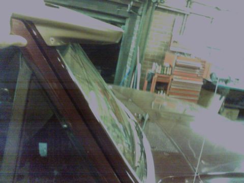 1988 Ford C-350 (Centurion Conversions) - Car visor and windshield frame with reflections of trees visible.