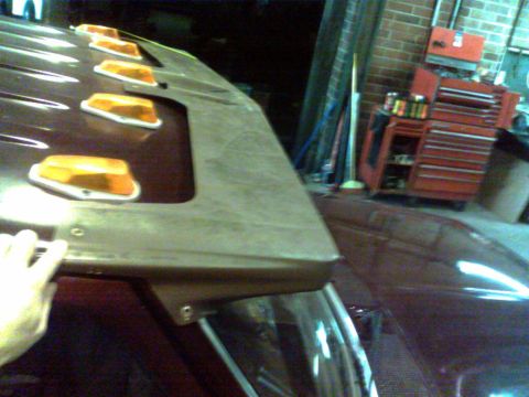 1988 Ford C-350 (Centurion Conversions) - A close-up view of amber cab lights and a visor on a truck's roof.