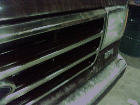 1988 Ford C-350 (Centurion Conversions) - Close-up of the front grille and headlight assembly of a dark-colored truck.