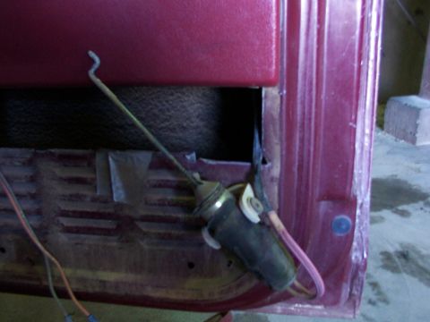 1988 Ford C-350 (Centurion Conversions) - Close-up of a door lock actuator mechanism and its connecting rod within a vehicle's interior door panel.