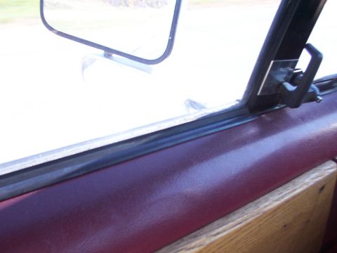 1988 Ford C-350 (Centurion Conversions) - Close-up of the interior door panel and window frame, showing trim and a latch.