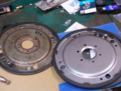 1988 Ford C-350 (Centurion Conversions) - Two flywheels are shown, one clean and one with visible wear and dirt, on a workbench.