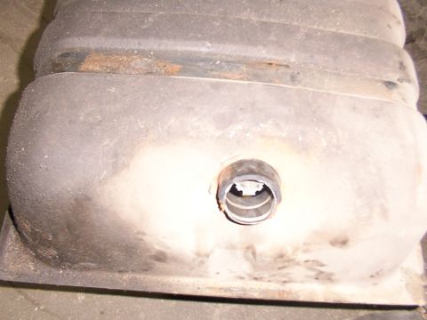 1988 Ford C-350 (Centurion Conversions) - A close-up view of a vehicle's fuel tank, showing a fitting and signs of wear.