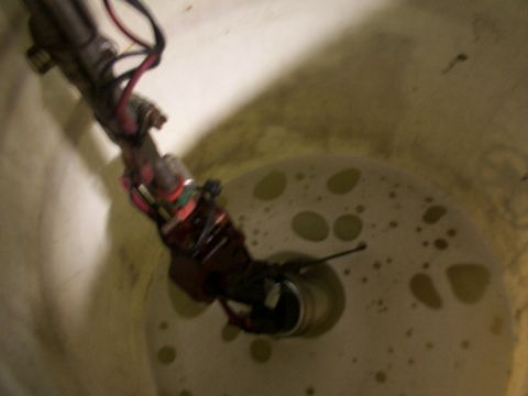 1988 Ford C-350 (Centurion Conversions) - A fuel pump assembly is shown submerged within a tank containing a yellow liquid.