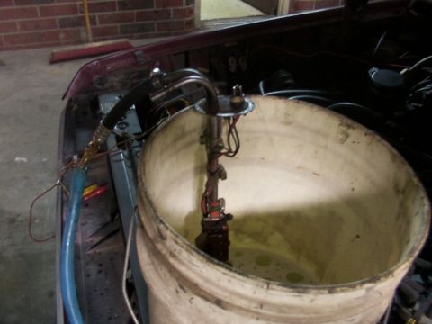 1988 Ford C-350 (Centurion Conversions) - A vehicle's fuel pump assembly is shown removed and placed in a bucket for service or testing.