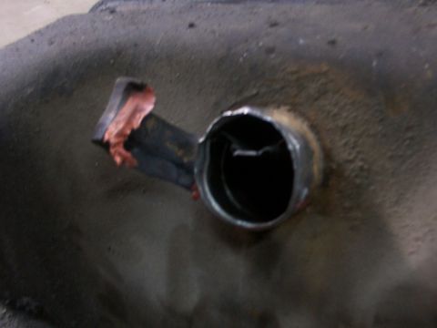 1988 Ford C-350 (Centurion Conversions) - A close-up view of a metal fitting on a fuel tank, showing a cut pipe attached.