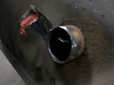 1988 Ford C-350 (Centurion Conversions) - Fuel tank filler neck showing damage and some red sealant or tape.
