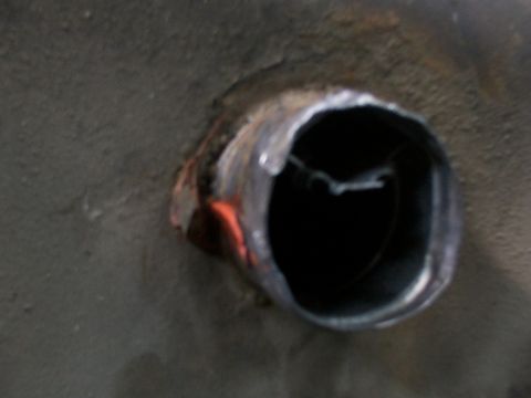 1988 Ford C-350 (Centurion Conversions) - A hole is visible in the gray metal surface, with some orange and metallic discoloration around the edges.