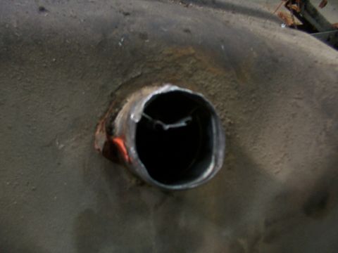 1988 Ford C-350 (Centurion Conversions) - Close-up view of a vehicle's fuel pump inlet, showing a metallic opening on a textured surface.