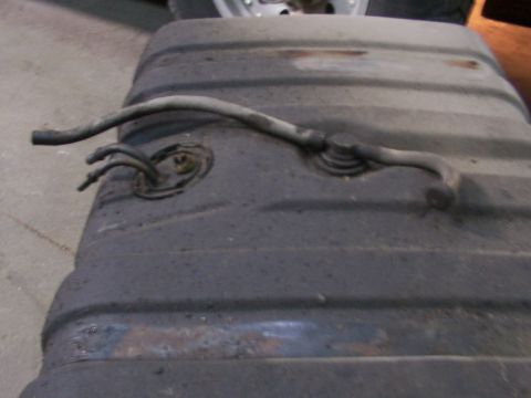 1988 Ford C-350 (Centurion Conversions) - A close-up view of a vehicle's fuel tank, showing hoses connected to a fitting.
