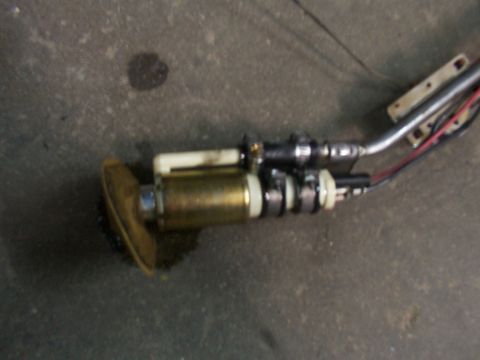 1988 Ford C-350 (Centurion Conversions) - A close-up view of a vehicle's fuel pump assembly, showing the pump, filter, and associated lines.