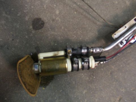 1988 Ford C-350 (Centurion Conversions) - A fuel pump assembly, likely for a vehicle, lies on a concrete surface.