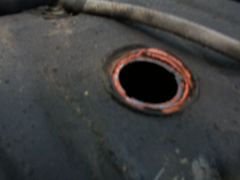 1988 Ford C-350 (Centurion Conversions) - Opening on a fuel tank with a hose nearby. The exact vehicle year and model are not identifiable from this part.