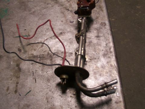 1988 Ford C-350 (Centurion Conversions) - A fuel pump sender unit with attached wiring and fuel lines rests on a textured metal surface.