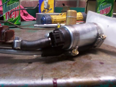 1988 Ford C-350 (Centurion Conversions) - Close-up of a fuel pump assembly, likely for a vehicle, on a cluttered workbench.