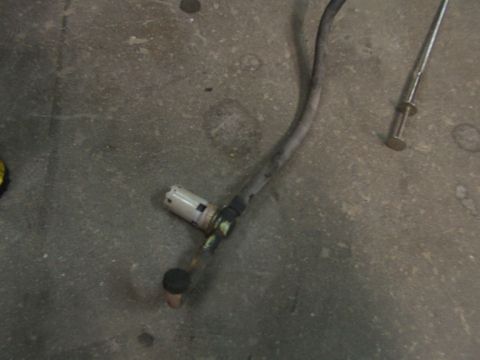1988 Ford C-350 (Centurion Conversions) - A close-up view of a fuel pump assembly with a hose and connector resting on a concrete surface.