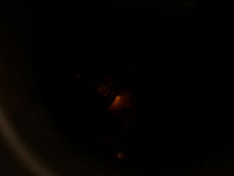 1988 Ford C-350 (Centurion Conversions) - A close-up view of a dark, unidentifiable vehicle component with an orange light source nearby.