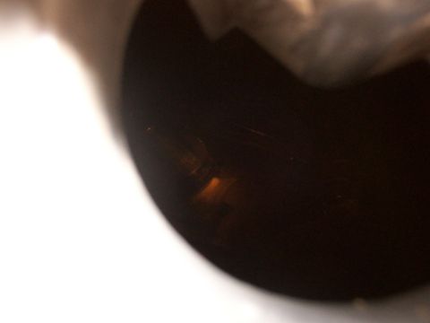 1988 Ford C-350 (Centurion Conversions) - A dark, curved object with a subtle orange light reflection is visible, possibly a component from a vehicle.