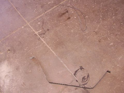 1988 Ford C-350 (Centurion Conversions) - Two metal straps, likely for a fuel tank, lie on a concrete surface.