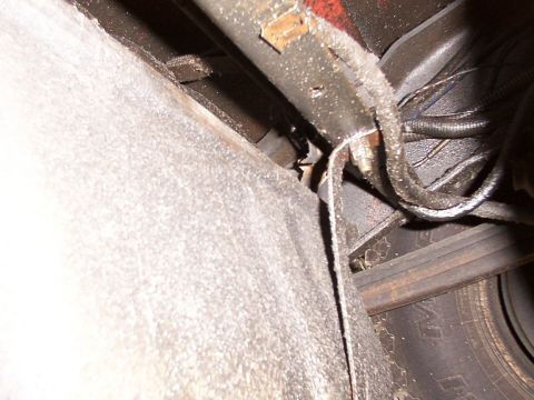 1988 Ford C-350 (Centurion Conversions) - Underside view of a vehicle's fuel tank straps and electrical wiring.