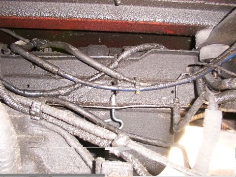 1988 Ford C-350 (Centurion Conversions) - Close-up of the underbody showing various wires and fuel lines, likely from a vehicle.