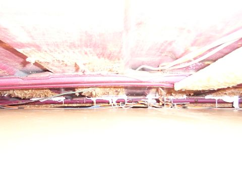 1988 Ford C-350 (Centurion Conversions) - Damage to the headliner reveals insulation and wiring beneath the roof structure.