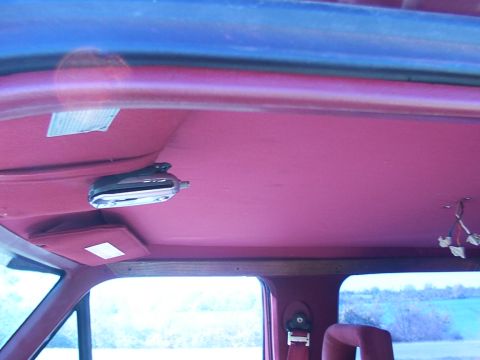 1988 Ford C-350 (Centurion Conversions) - The interior of a vehicle shows a pink headliner with a dome light and a sun visor.