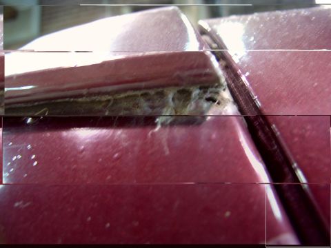 1988 Ford C-350 (Centurion Conversions) - Close-up of a damaged section of a vehicle's exterior, showing a hole under the drip rail.