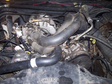 1985 Ford Bronco - Close-up view of a vehicle's engine compartment, showing various mechanical components and wiring.