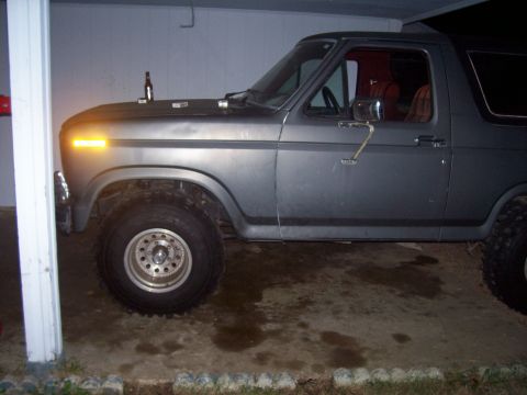 1985 Ford Bronco - This 1985 Ford Bronco is shown from the side, its off-road tires and a utilitarian gray exterior.