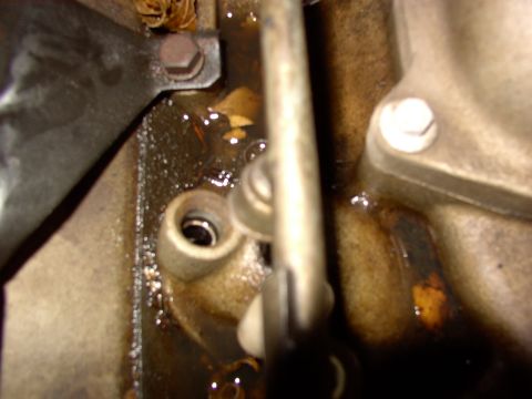 1988 Ford C-350 (Centurion Conversions) - Engine part showing an oil leak and some debris collected around it.
