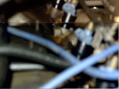 1988 Ford C-350 (Centurion Conversions) - A close-up view of engine injectors, likely from a Ford C-350, with prominent blue fuel lines visible.