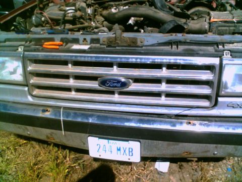 1988 Ford C-350 (Centurion Conversions) - Front view of a Ford truck's grille and engine bay, showing the Ford emblem and a license plate.