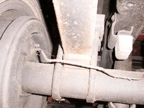 1988 Ford C-350 (Centurion Conversions) - Underside view of a vehicle's rear axle and suspension system, focusing on the brake drum and leaf springs.