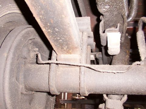 1988 Ford C-350 (Centurion Conversions) - Close-up view of the rear axle and suspension system of a vehicle.