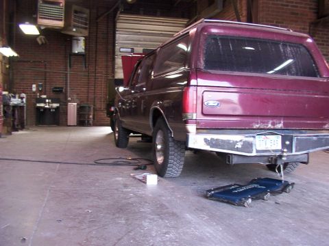 1988 Ford C-350 (Centurion Conversions) - A maroon Ford Bronco is parked in a garage with its hood up, showing the rear of the vehicle.