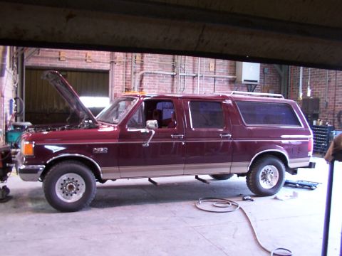 1988 Ford C-350 (Centurion Conversions) - Maroon extended cab pickup truck with a camper shell, side view. The badge on the fender reads 'F250'.