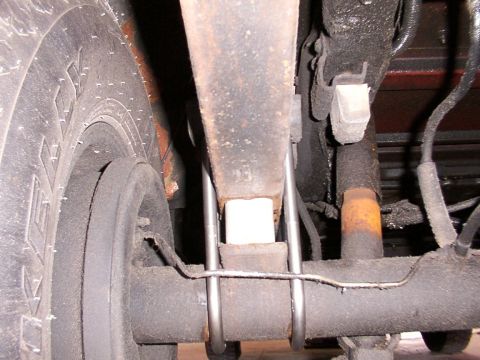 1988 Ford C-350 (Centurion Conversions) - Close-up view of the rear suspension system, highlighting the leaf springs and lift blocks.