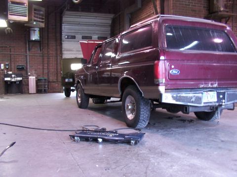 1988 Ford C-350 (Centurion Conversions) - Maroon SUV with hood open, seen from the rear 3/4 angle in a garage. Another vehicle is visible in the background.