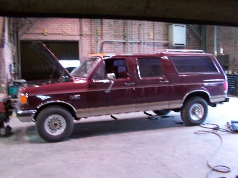 1988 Ford C-350 (Centurion Conversions) - Side view of a maroon extended cab pickup truck with a camper shell, hood is open. Likely a Ford F-Series from the late 80s.